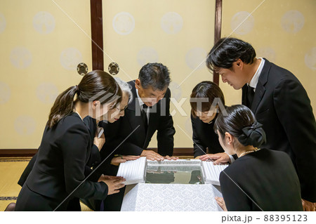 お葬式で納棺の儀をする遺族 88395123