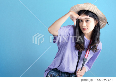 Asian woman with hat and camera looking at something Asian woman with hat and camera looking at something 88395371