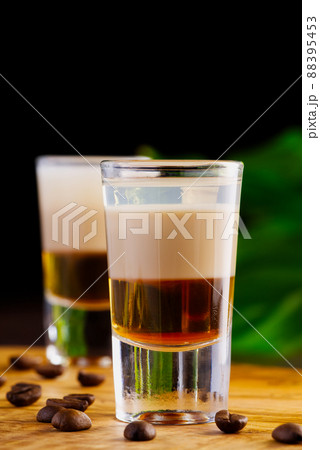 Shots of flaming B-52 cocktail placed on a bar counter. B-52 shot composed of three liqueurs 88395453