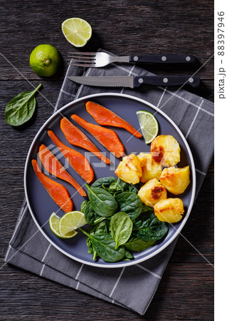 salmon slices with spinach leaves, roast potatoes salmon slices with spinach leaves, roast potatoes 88397946