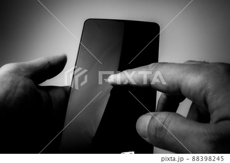 スマホを操作するシーン モノクロイメージ スマホを操作するシーン モノクロイメージ 88398245