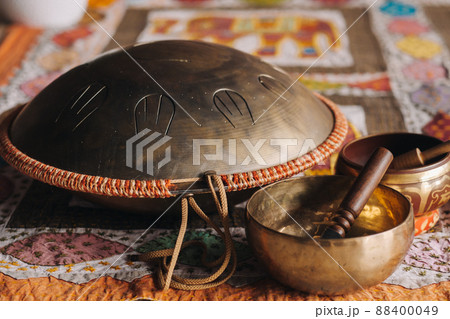 Tongue drum and Tibetan bowls lying on the carpet Tongue drum and Tibetan bowls lying on the carpet 88400049