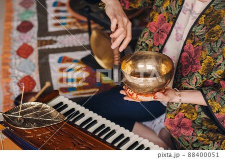 Tibetan singing bowl in the hands of a man during a tea ceremony Tibetan singing bowl in the hands of a man during a tea ceremony 88400051