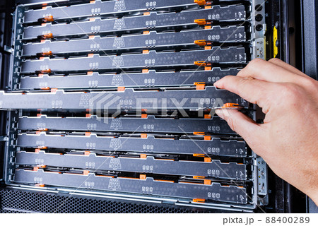 network administrator installing data storage hardware from sever rack 88400289
