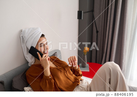 Young smiling female in brown blouse and white linen pants calling someone 88406195