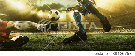 Close-up legs of soccer, football players in action, motion at the stadium with flashlights and crowded stands. Concept of sport, competition, movement, overcoming. Close-up legs of soccer, football players in action, motion at the stadium with flashlights and crowded stands. Concept of sport, competition, movement, overcoming. 88406768