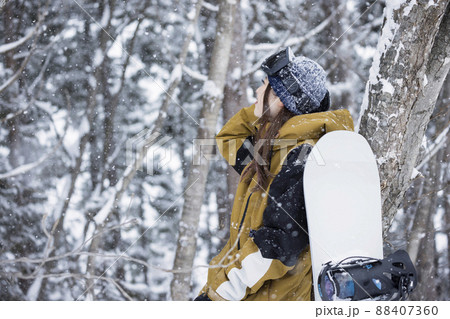 雪の降るスキー場に立つスノボ女子 雪の降るスキー場に立つスノボ女子 88407360