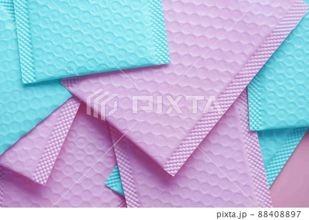 pink and green color paper bubble envelope on table  88408897
