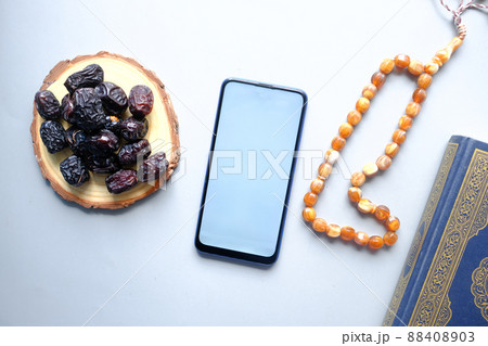 smart phone, Holy book Quran and rosary on table,  88408903
