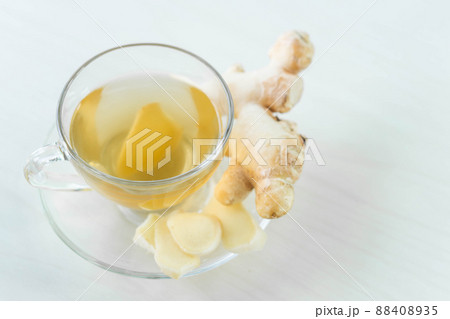 Closeup Fresh ginger with sliced and hot ginger glass on white white table, herb and medical for health concept, copy space 88408935