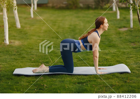 Beautiful girl training. Girl in a summer park. Lady make a yoga Beautiful girl training. Girl in a summer park. Lady make a yoga 88412206
