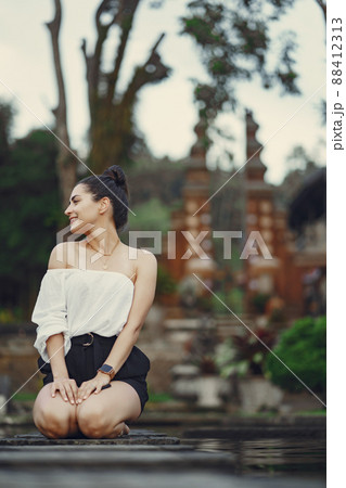 girl exploring a beautiful park in Bali. Brunette girl dressed in stylish clothing posing in a beautiful location girl exploring a beautiful park in Bali. Brunette girl dressed in stylish clothing posing in a beautiful location 88412313