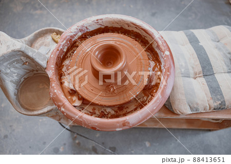 Photo of clay product on pottery wheel in workroom Photo of clay product on pottery wheel in workroom 88413651