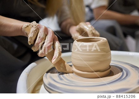 Close up shot of hands of crafts people, working with clay in pottery studio. Close up shot of hands of crafts people, working with clay in pottery studio. 88415206