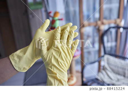 Young man wearing yellow rubber gloves. Ready to cleaning. 88415224
