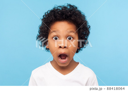 Wow, unbelievable. Portrait of funny amazed little boy looking at camera with shocked astonished expression, emotionally reacting to surprising news. indoor studio shot isolated on blue background 88418064