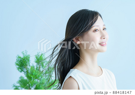 髪がなびいて笑顔の若い女性 88418147