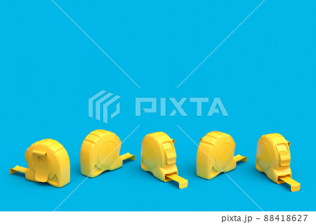 Set of yellow carpenter measuring tape on blue background with units scale 88418627