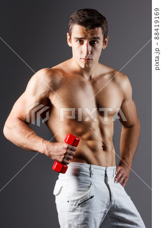 pain relief, sport, bodybuilding, strength and people concept - young man standing over black background 88419169