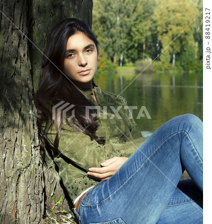 Young cute smiling real stylish dressed woman in green palm park smiling, resting, enjoing, lifestyle outside concept Young cute smiling real stylish dressed woman in green palm park smiling, resting, enjoing, lifestyle outside concept 88419217