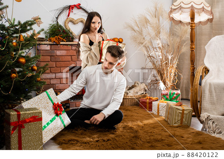 The fianc e gives a gift to her lover on Christmas Day. A unique Christmas atmosphere. A surprise during the holidays. The fianc e gives a gift to her lover on Christmas Day. A unique Christmas atmosphere. A surprise during the holidays. 88420122