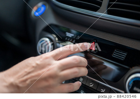 Close-up of a woman's hand pressing the emergency button in a new car. Close-up of a woman's hand pressing the emergency button in a new car. 88420546