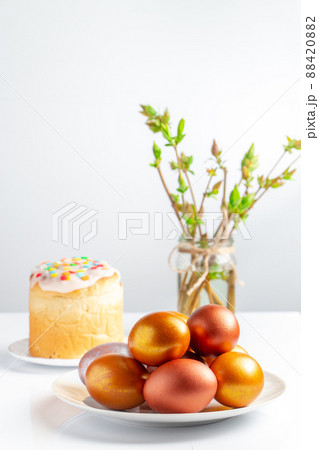 Easter cake with sweet icing and golden eggs on white plate. 88420882