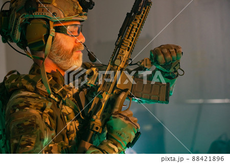 Cropped image of bearded man in military uniform with gun Cropped image of bearded man in military uniform with gun 88421896