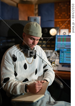 Portrait of confident young music producer writing in notepad Portrait of confident young music producer writing in notepad 88422050