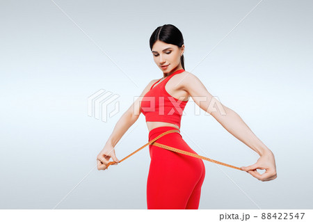 Concept of healthy eating. Fitness woman measuring waist Concept of healthy eating. Fitness woman measuring waist 88422547