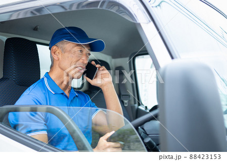 トラックを運転するミドルの男性ドライバー トラックを運転するミドルの男性ドライバー 88423153
