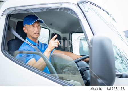 トラックを運転するミドルの男性ドライバー トラックを運転するミドルの男性ドライバー 88423158