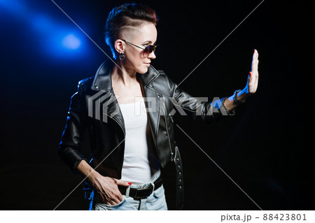 Stylish short haired brunette woman in black leather jacket wearing sunglasses 88423801