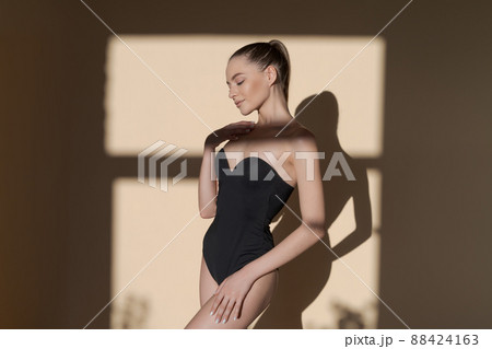 Perfect slim toned young girl body legs and hips wearing black body swimsuit. Perfect slim toned young girl body legs and hips wearing black body swimsuit. 88424163