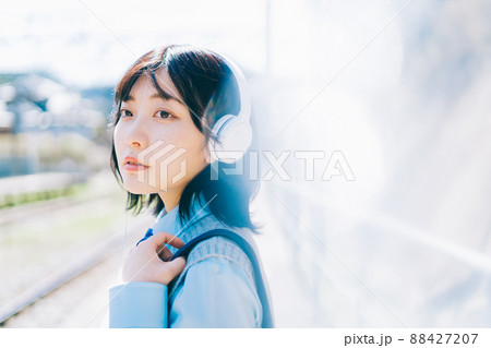 駅のホームで音楽を聴く女子高生 88427207