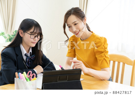 タブレットを用いながら勉強を教える家庭教師と女子高生 タブレットを用いながら勉強を教える家庭教師と女子高生 88427817