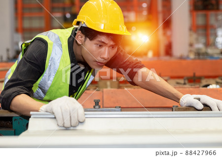 Asian male workers wear red helmet working check up iron production in factory. 88427966
