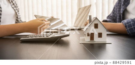 House model with agent and customer discussing for contract to buy, get insurance or loan real estate or property. House model with agent and customer discussing for contract to buy, get insurance or loan real estate or property. 88429591