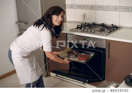 Chef in white clothes prepares a chocolate cake. Lady is preparing dessert. Woman bakes a cake. Chef in white clothes prepares a chocolate cake. Lady is preparing dessert. Woman bakes a cake. 88429592