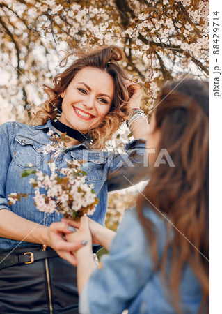 Fashionable mother with daughter. Family in a spring park. Woman in a blue shirt Fashionable mother with daughter. Family in a spring park. Woman in a blue shirt 88429714