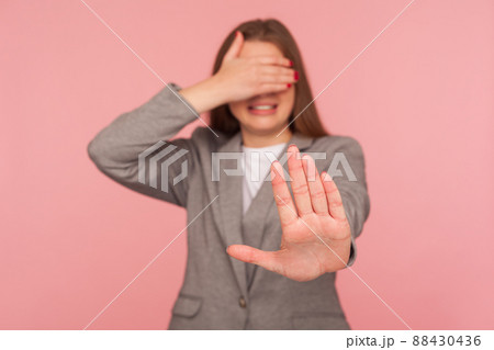 Don't show me. Portrait of displeased young woman in business suit covering eyes and gesturing stop, her face expressing disgust gross and shame, refusing to watch. indoor studio shot, isolated 88430436