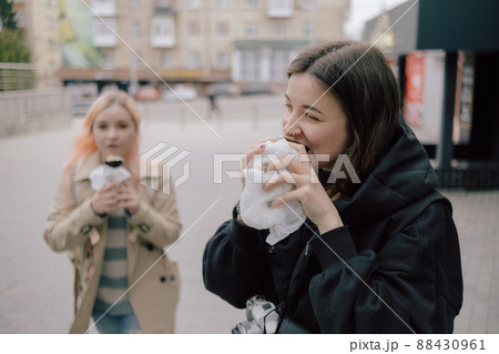 LGBT Lesbian couple eat sushi rolls on the walk asian cafe. street food LGBT Lesbian couple eat sushi rolls on the walk asian cafe. street food 88430961