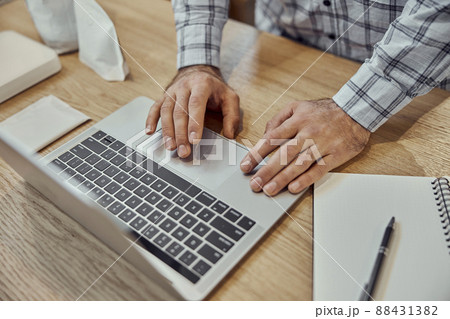 Male hands using modern laptop on wooden table Male hands using modern laptop on wooden table 88431382