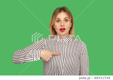 This is me. Amazed pretty girl with red lips pointing to herself with wondered expression, pleasantly surprised by own success, disbelief reaction. indoor studio shot isolated on green background This is me. Amazed pretty girl with red lips pointing to herself with wondered expression, pleasantly surprised by own success, disbelief reaction. indoor studio shot isolated on green background 88431548