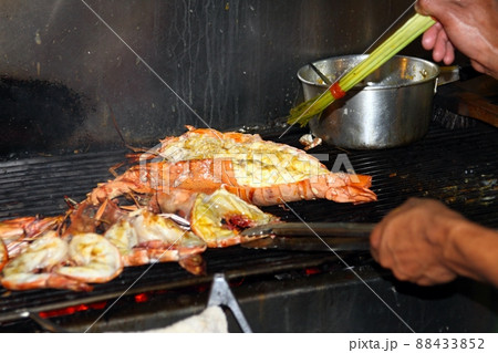 Lobsters grilled over charcoal stove at the street market. 88433852