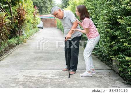 Asian senior man walking in the backyard and painful inflammation and stiffness of the joints (Arthritis) and the daughter came to help support. Concept of old elderly insurance and health care Asian senior man walking in the backyard and painful inflammation and stiffness of the joints (Arthritis) and the daughter came to help support. Concept of old elderly insurance and health care 88435116