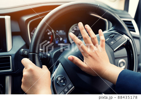 man pushing horn while driving sitting of a steering wheel press car, honking sound to warn other people in traffic concept. 88435178