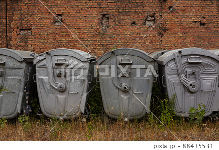 Metal trash containers. Group of waste containers against the wall. Metal trash containers. Group of waste containers against the wall. 88435531