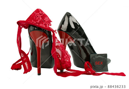 Red lace panties, bra, condom and shoes on high heels on the fur