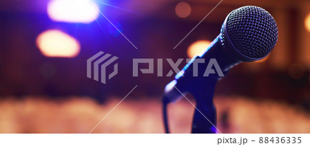 Close up of microphone on stage lighting at concert hall or conference room. copy space banner. soft focus. Close up of microphone on stage lighting at concert hall or conference room. copy space banner. soft focus. 88436335